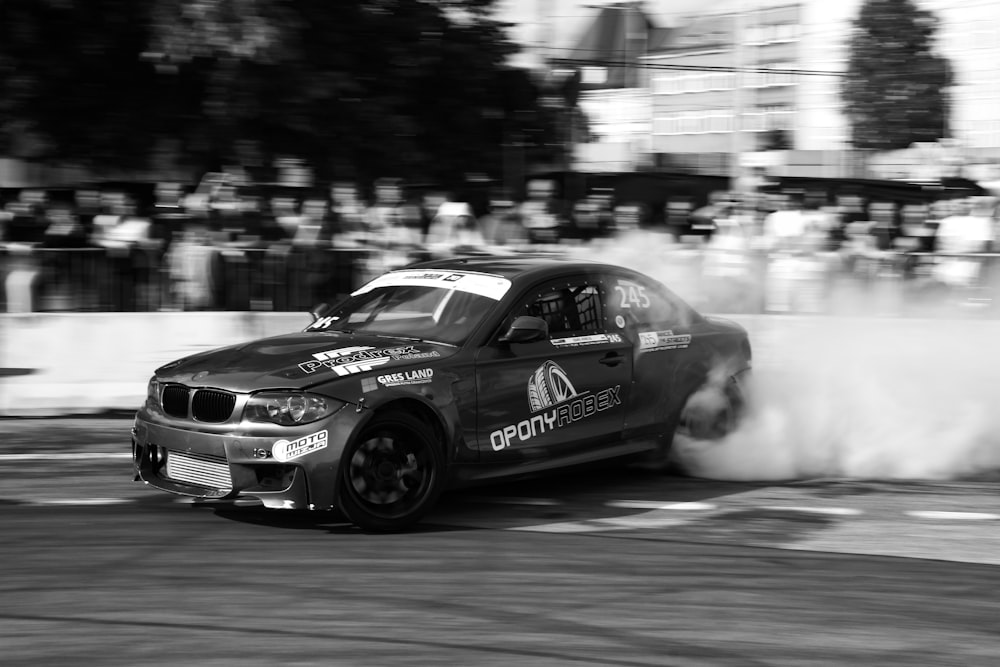 a black and white photo of a car with smoke coming out of it