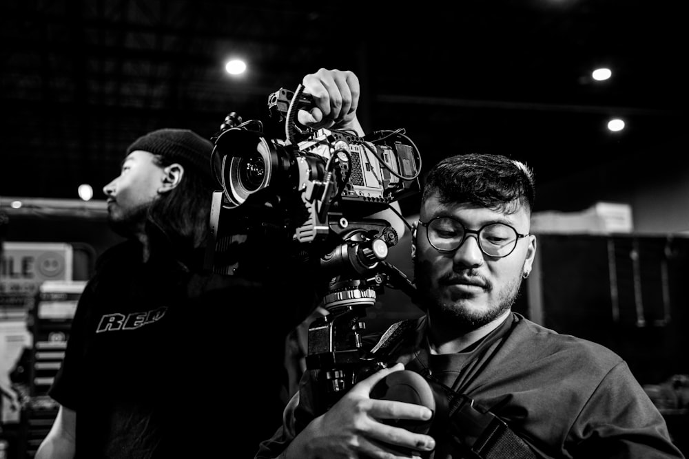 a black and white photo of a man holding a camera