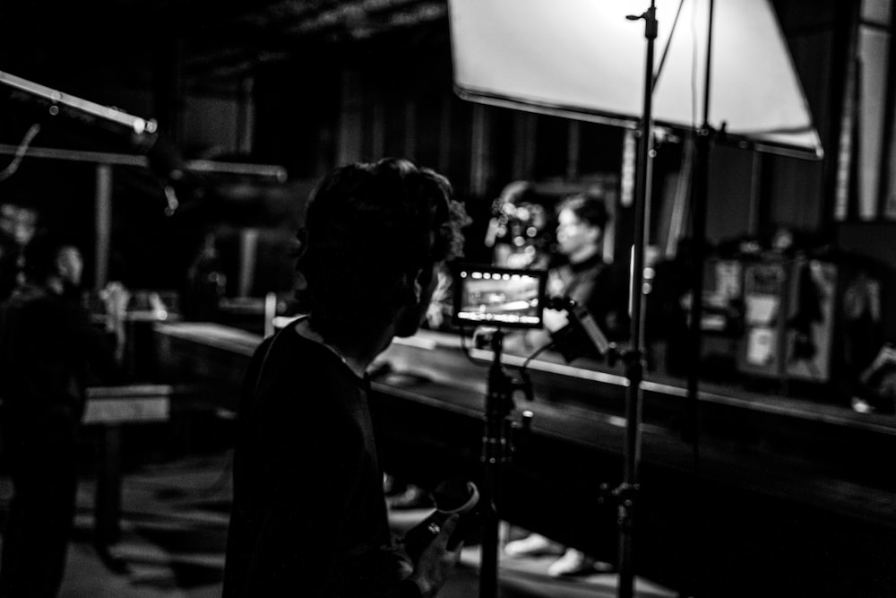 uma foto em preto e branco de uma pessoa em um estúdio de gravação