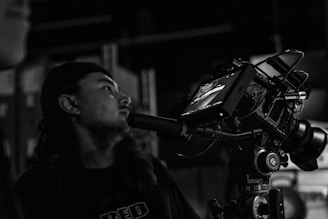 a man standing next to a camera on a tripod