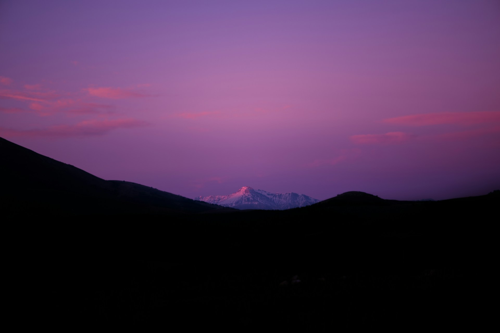 a purple sky with a mountain in the distance