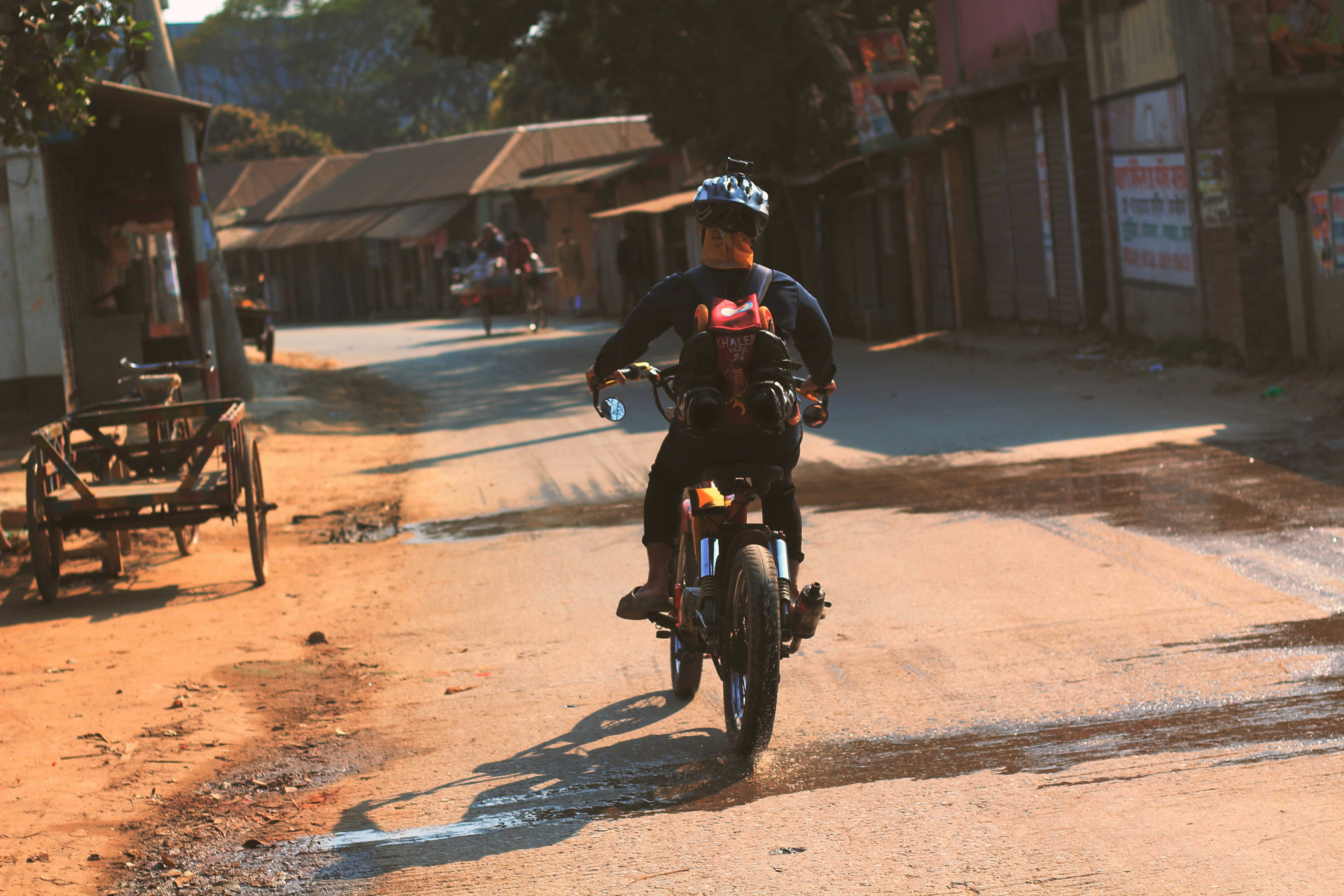 a man riding a motorcycle down a dirt road