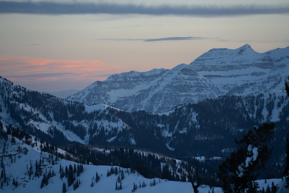 a view of a snowy mountain range at sunset