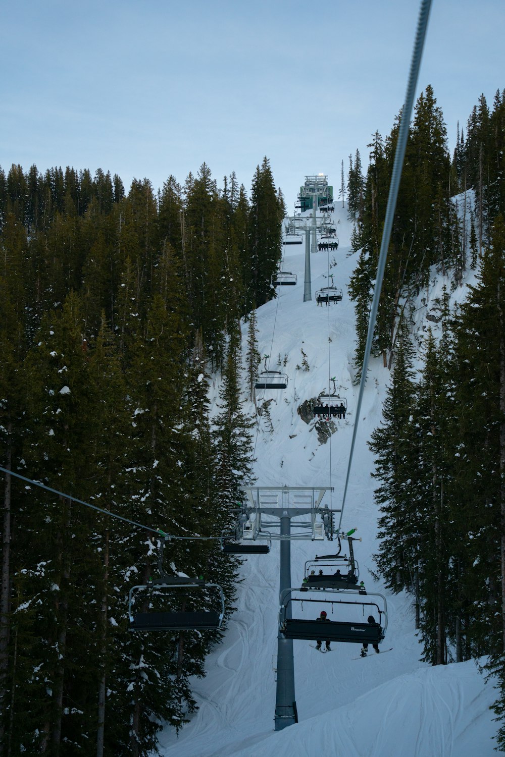 um teleférico subindo uma montanha nevada