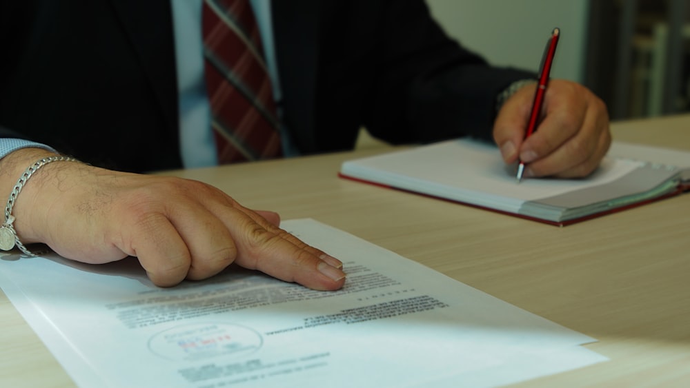 a man in a suit signing a document with a pen