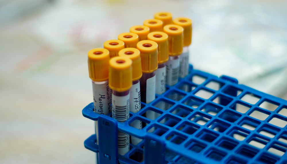 a group of orange and blue tubes sitting on top of a blue container