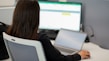 a woman sitting in front of a laptop computer