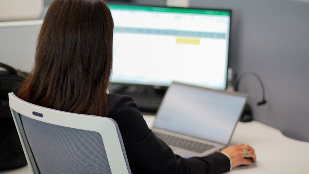 a woman sitting in front of a laptop computer