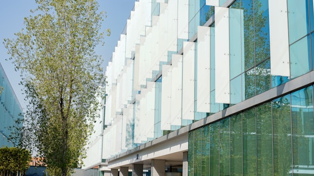a building with a lot of windows and a tree in front of it