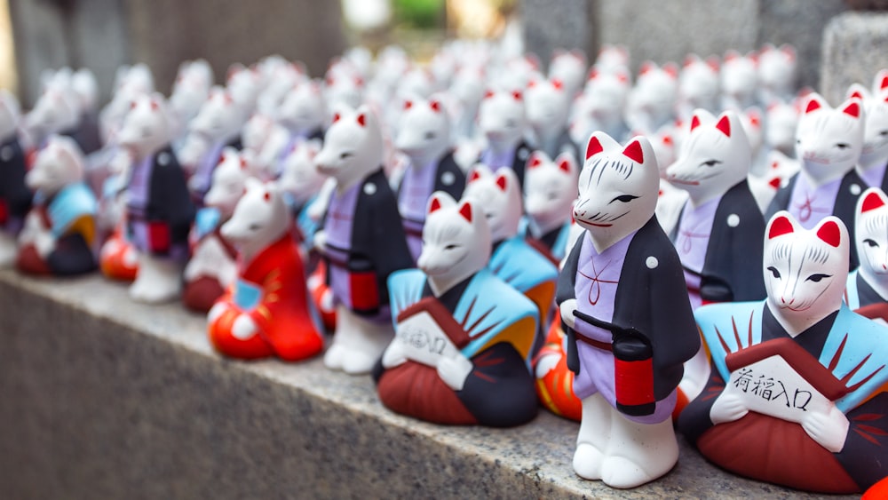 a row of ceramic cats sitting next to each other