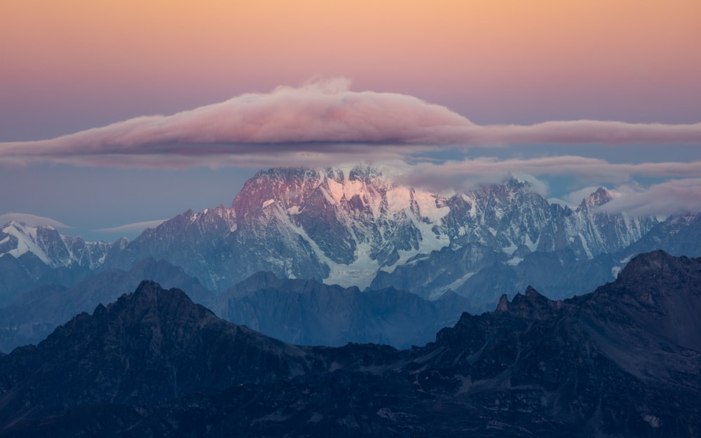 a view of a mountain range with a cloud in the sky