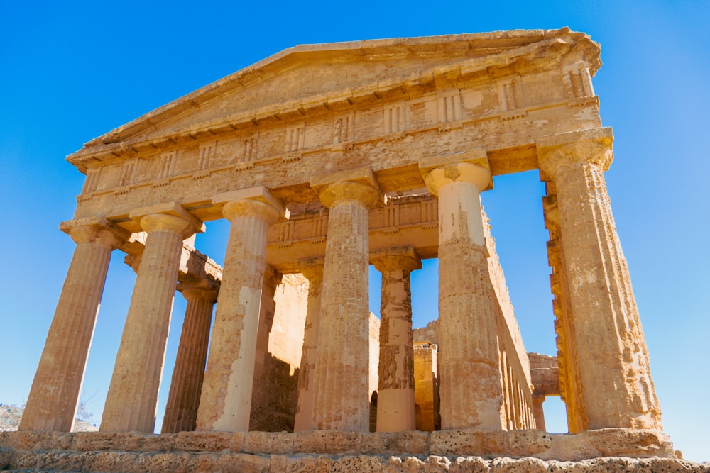 a large stone structure with columns and a sky background