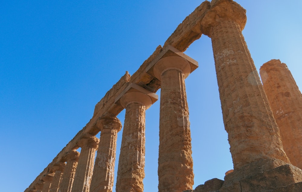 a row of stone pillars against a blue sky