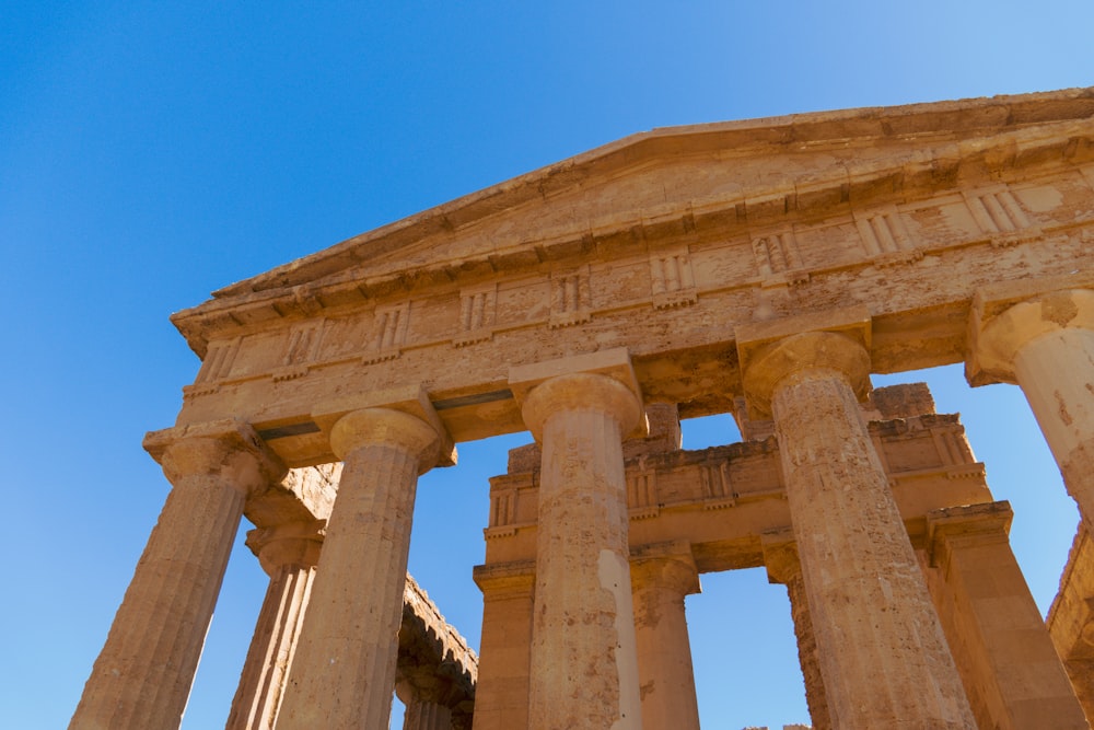 a large stone structure with columns and a sky background