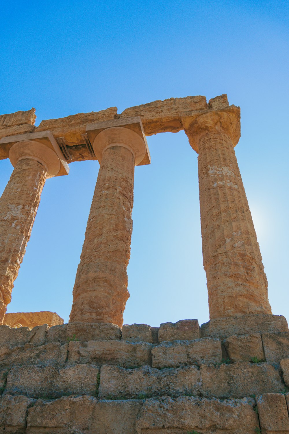 two large stone pillars against a blue sky