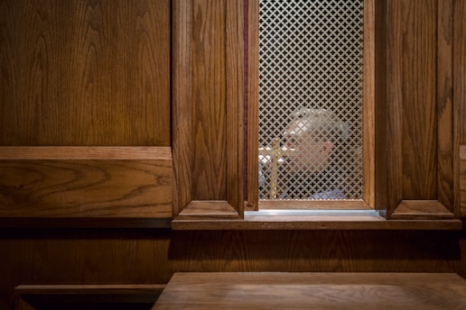 a man looking through a window in a wooden building