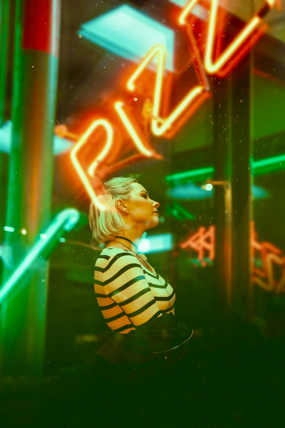 a woman standing in front of a neon sign