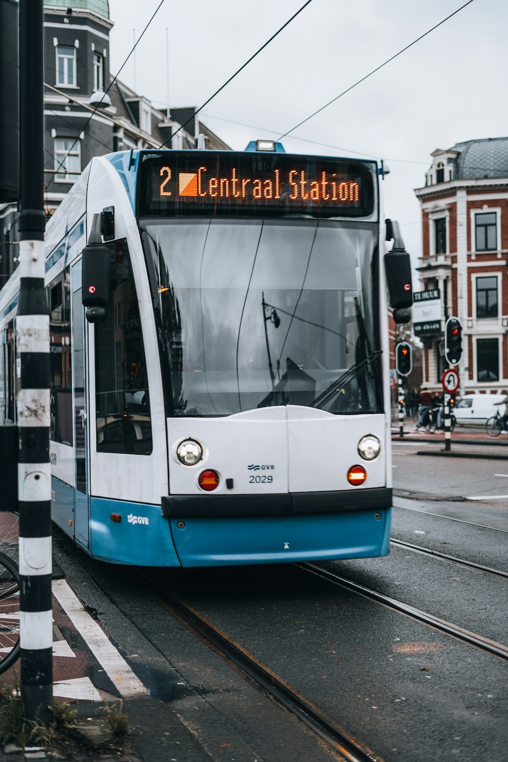 a blue and white bus driving down a street