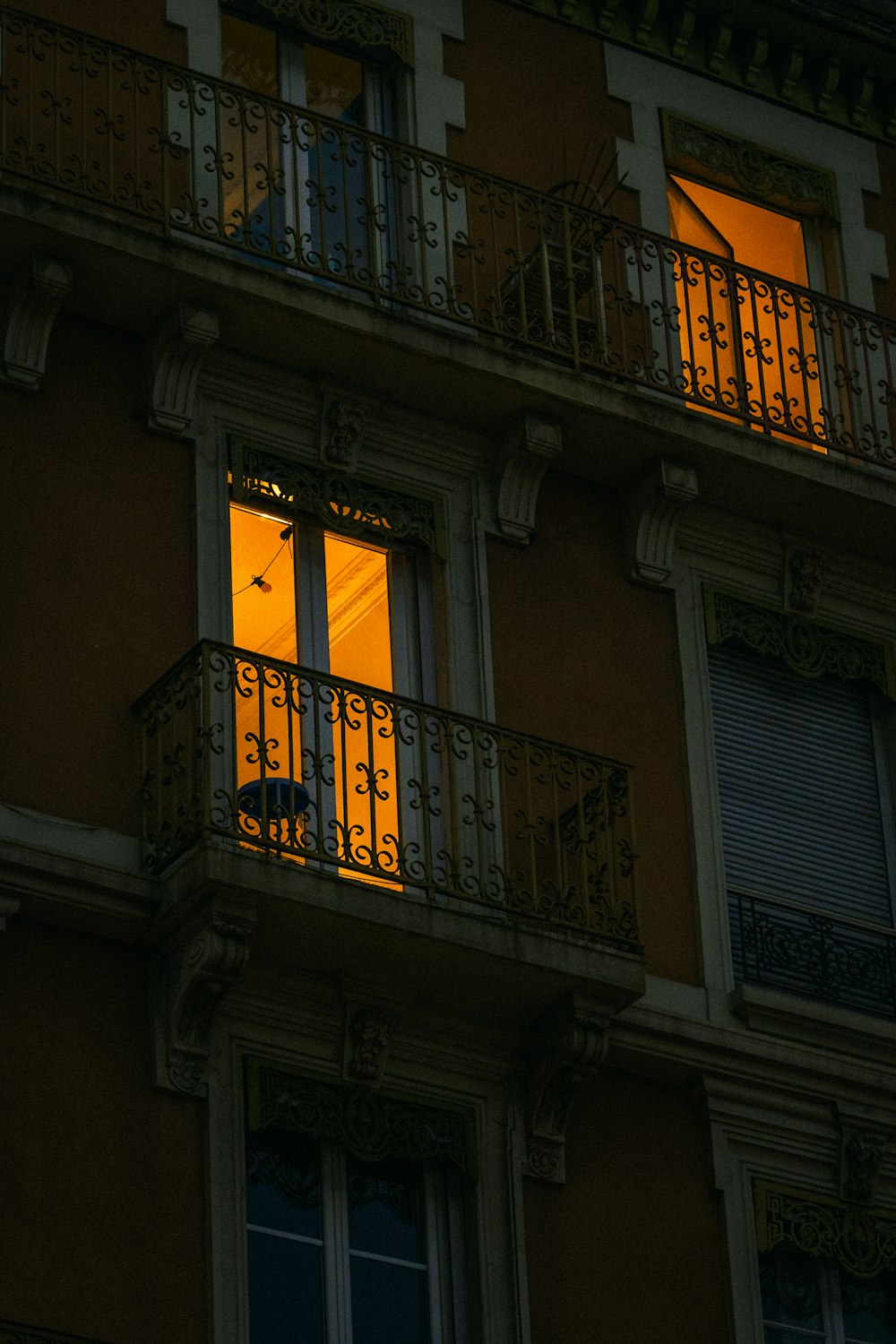 an apartment building with a balcony and balconies lit up at night