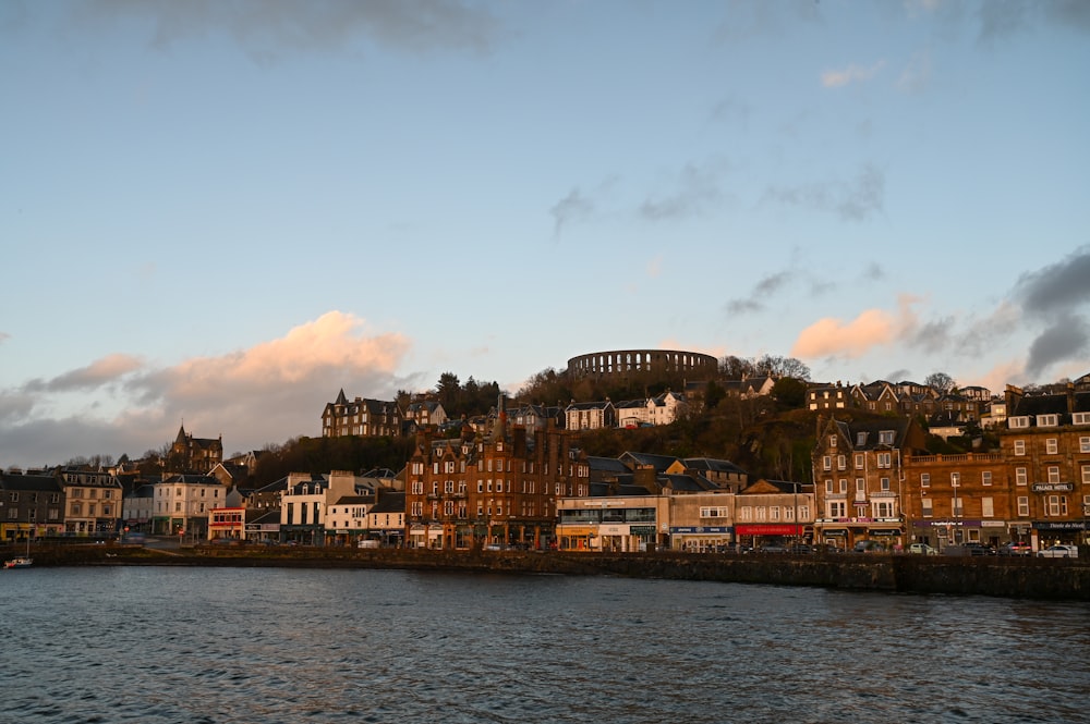 a large body of water with buildings on a hill in the background