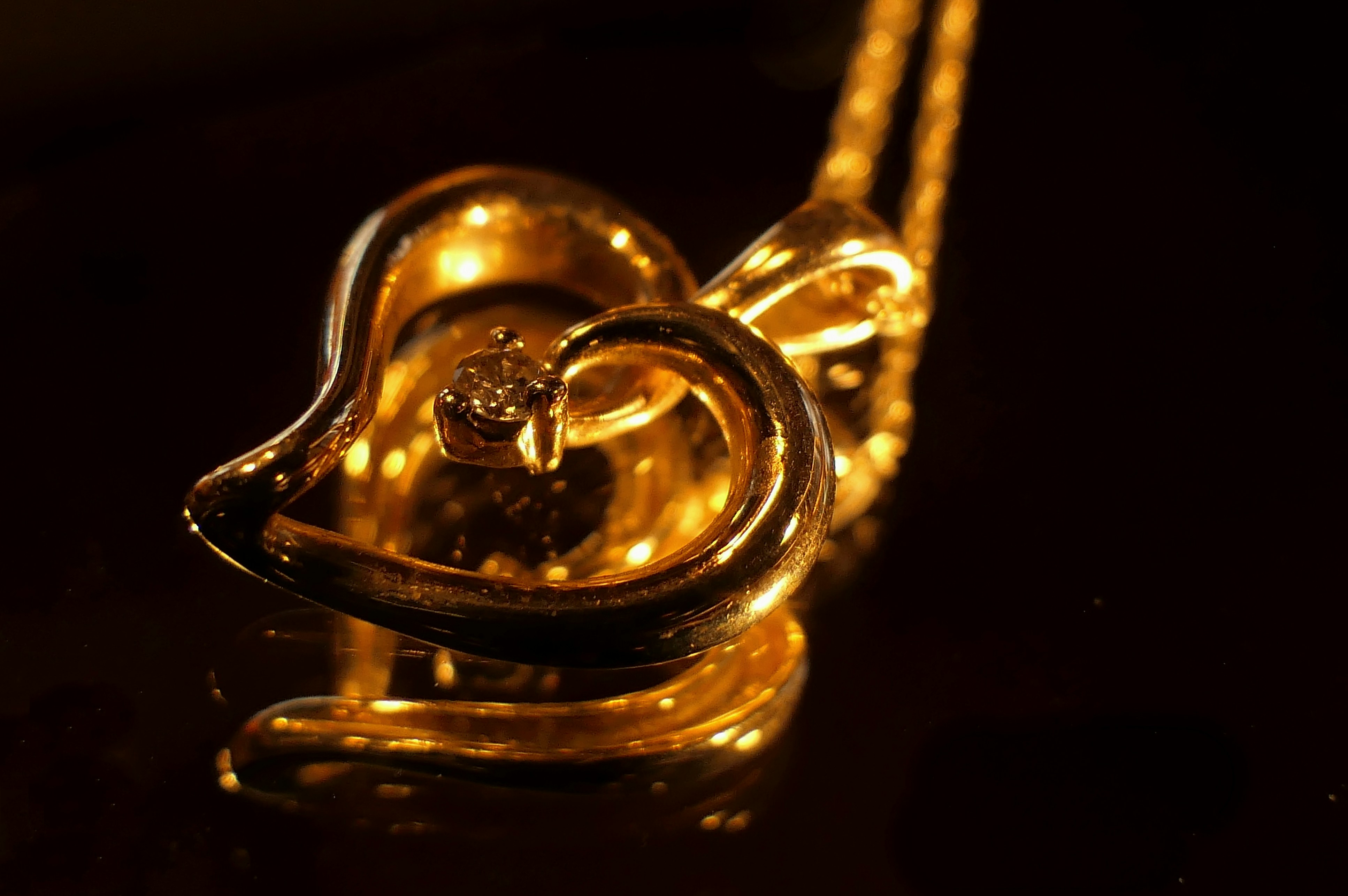 gold heart pendant and chain reflecting on mirror