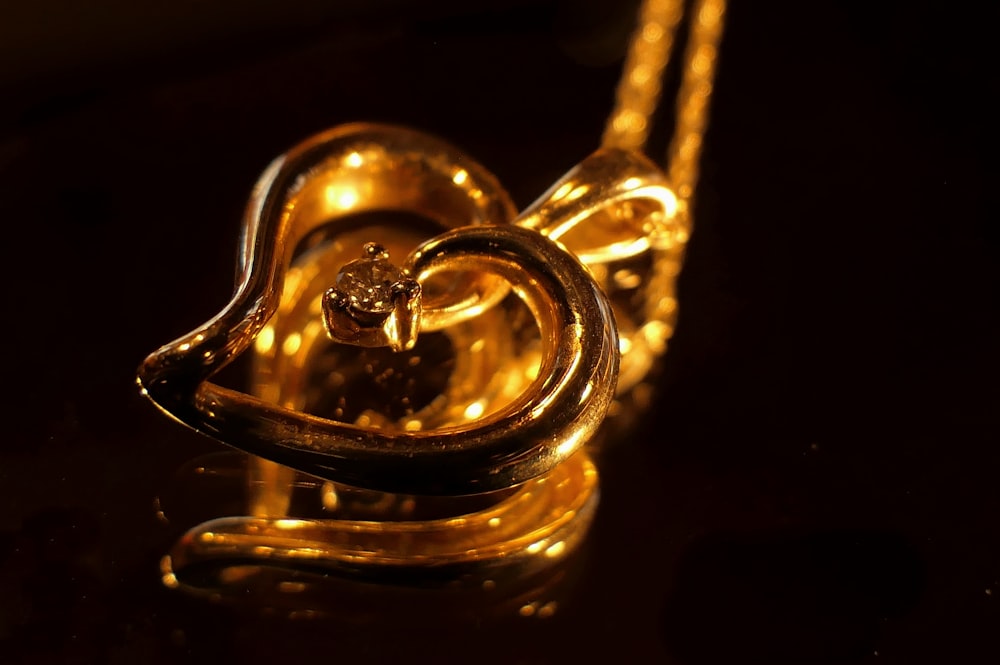 a gold necklace with a diamond in the shape of a heart