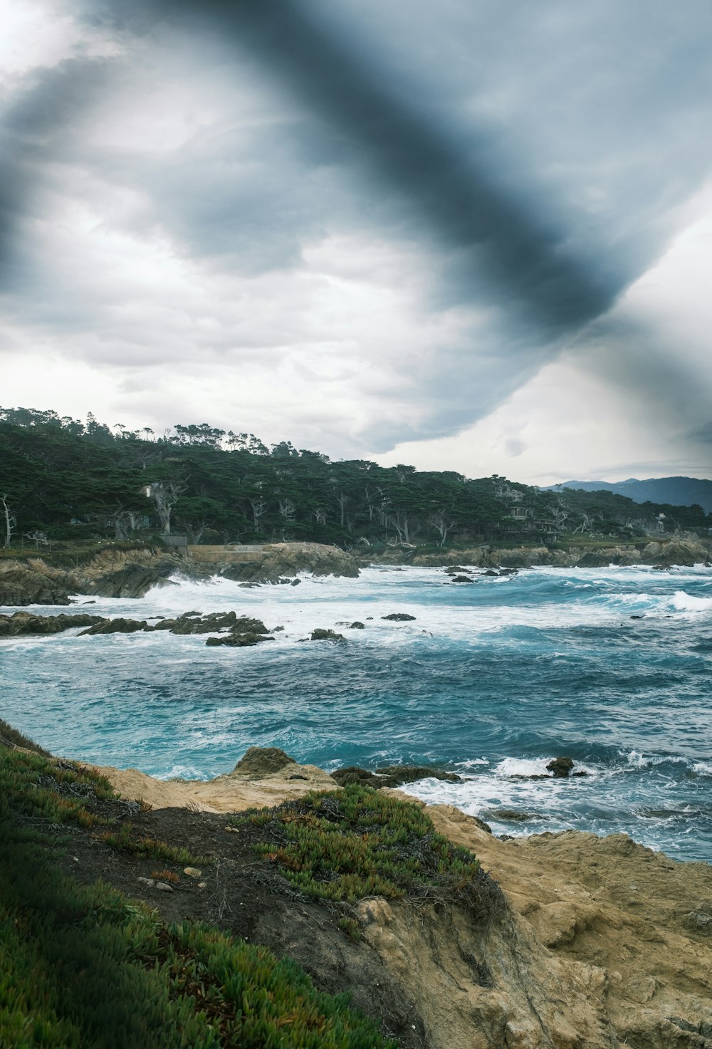 a large body of water sitting next to a lush green hillside