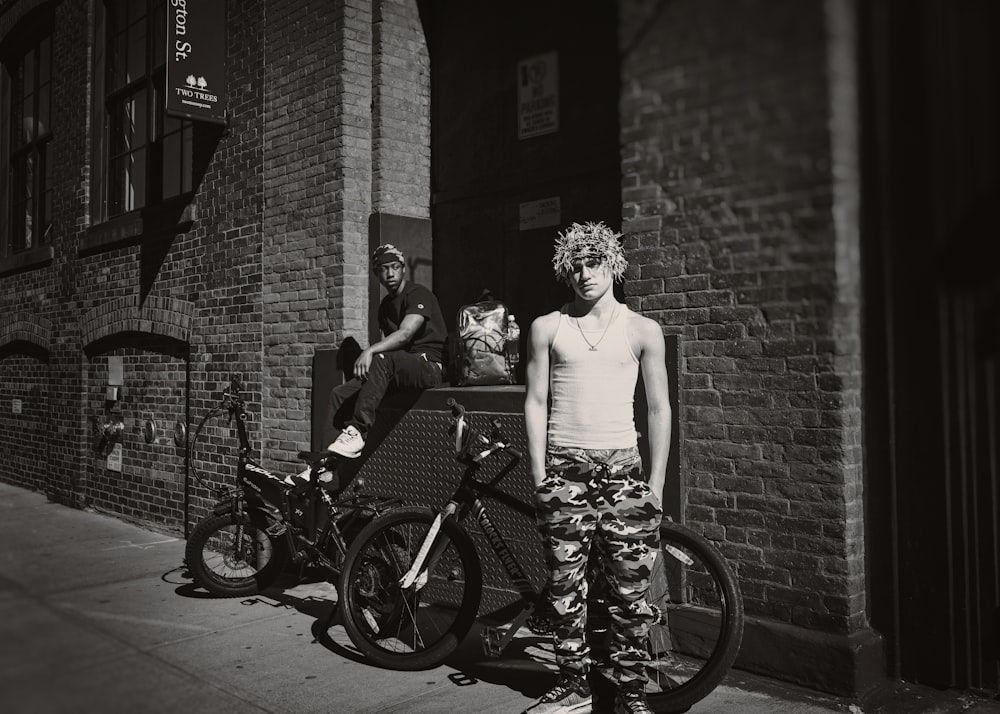 a man standing next to a bike on a sidewalk