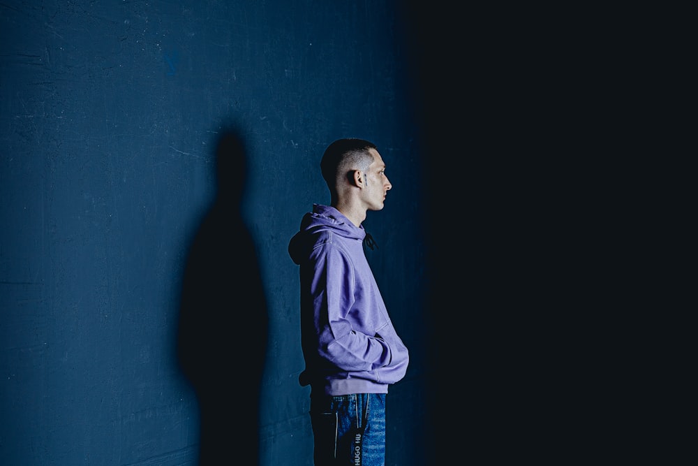 a man standing in front of a blue wall