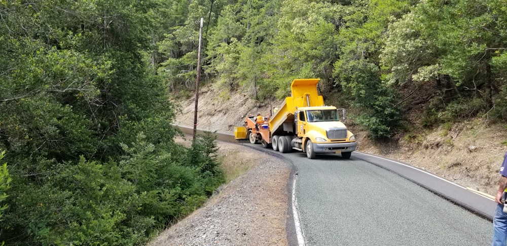 a man standing on the side of a road next to a truck