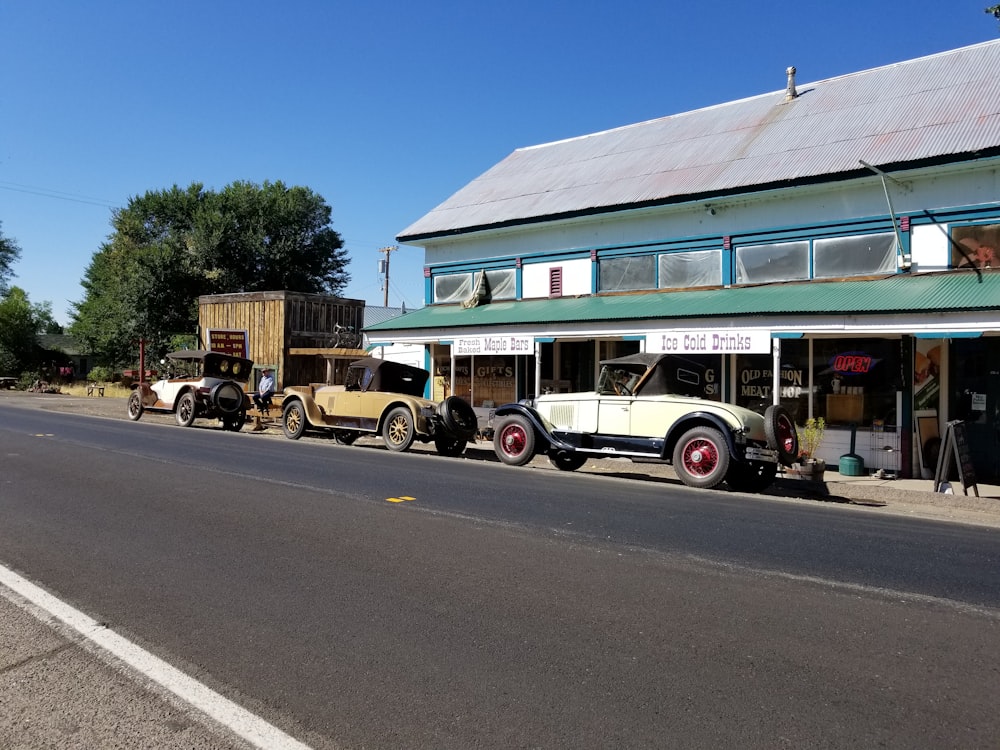 a row of antique cars parked in front of a building