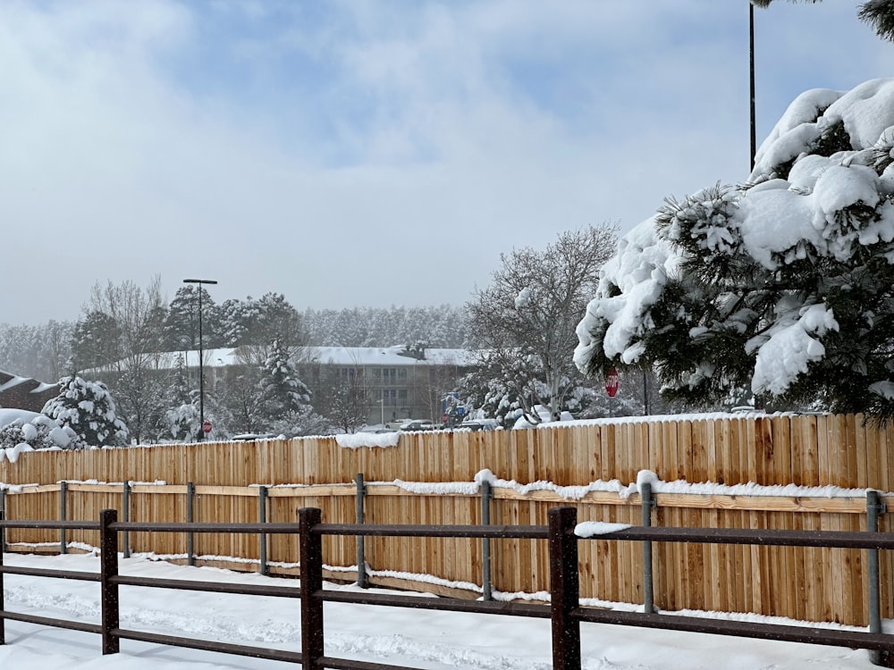 a wooden fence is covered in snow