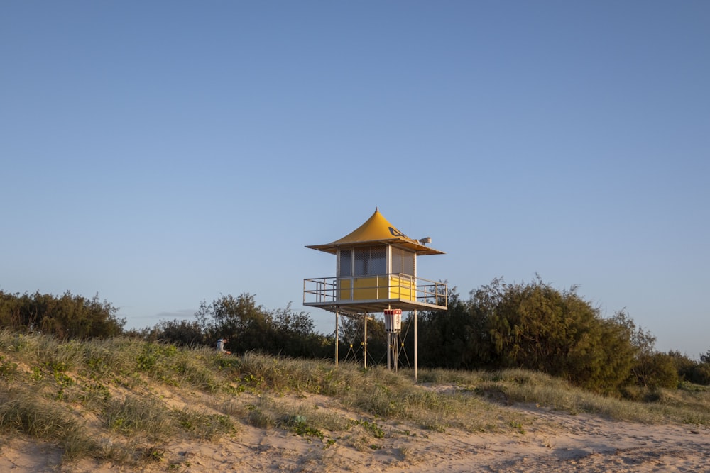 a lifeguard tower on top of a sandy hill