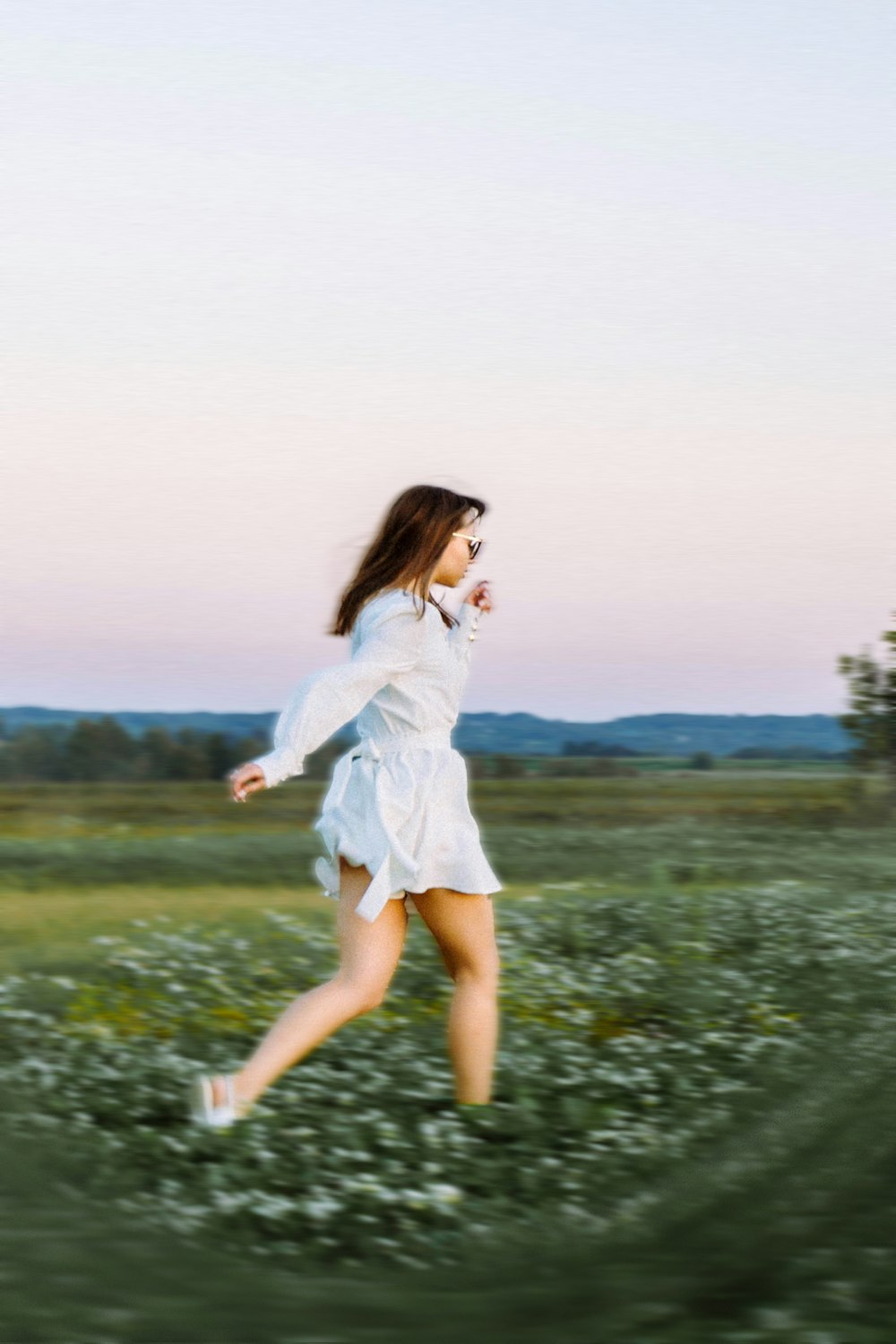 a woman in a white dress running through a field