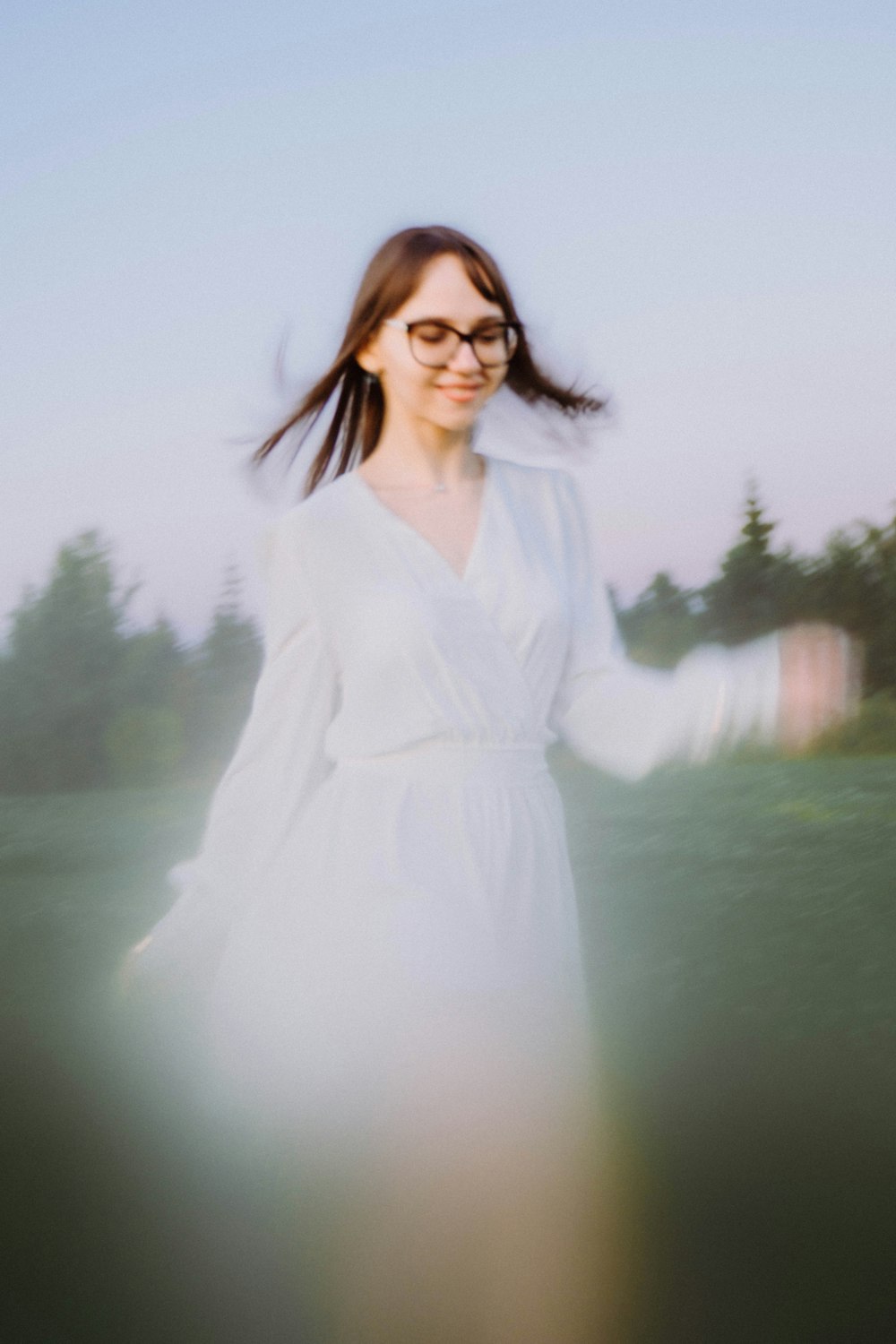 a woman wearing glasses and a white dress