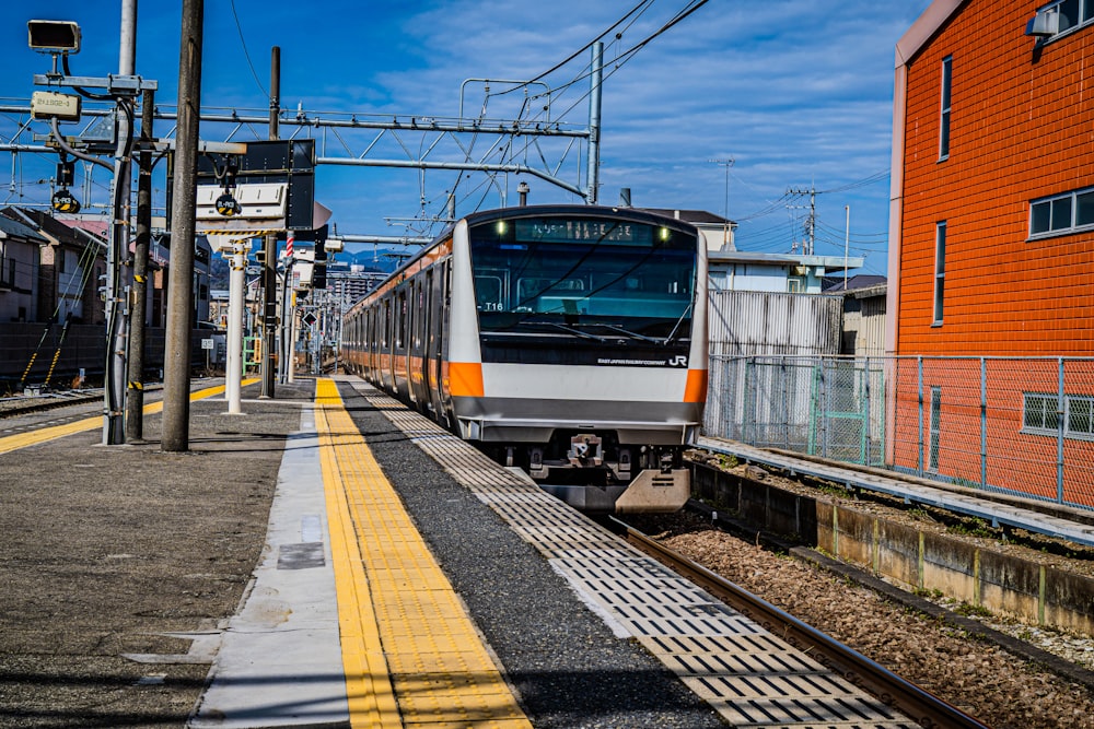 a train traveling down train tracks next to a building