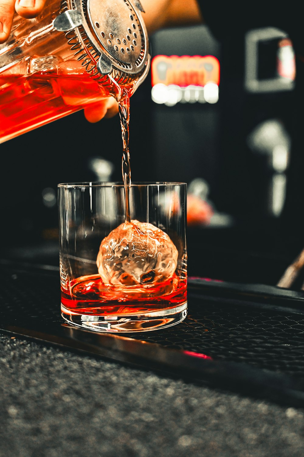 a person pouring a drink into a glass