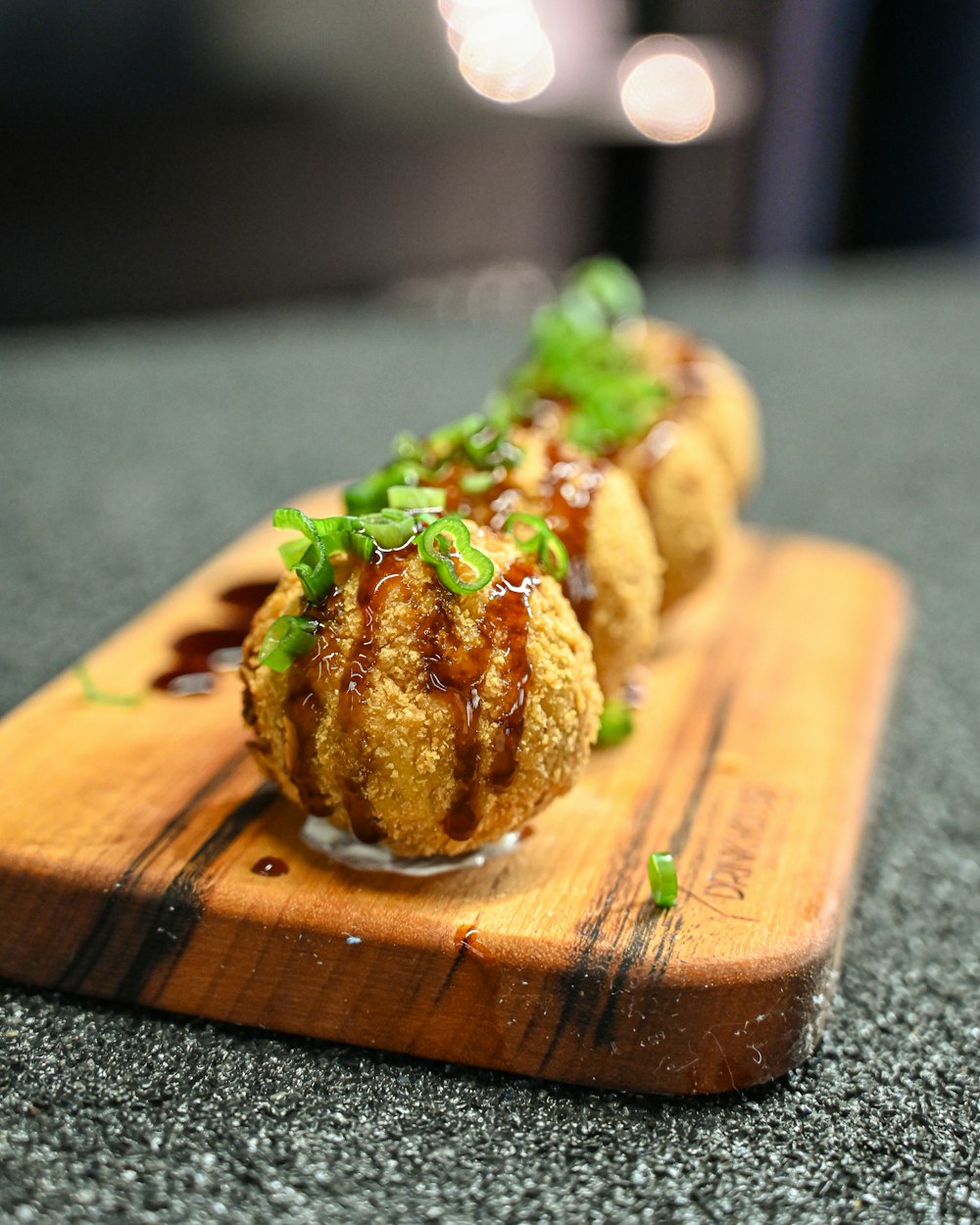 a wooden cutting board topped with food on top of a table