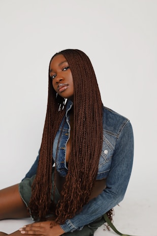 a woman sitting on the ground wearing a jean jacket