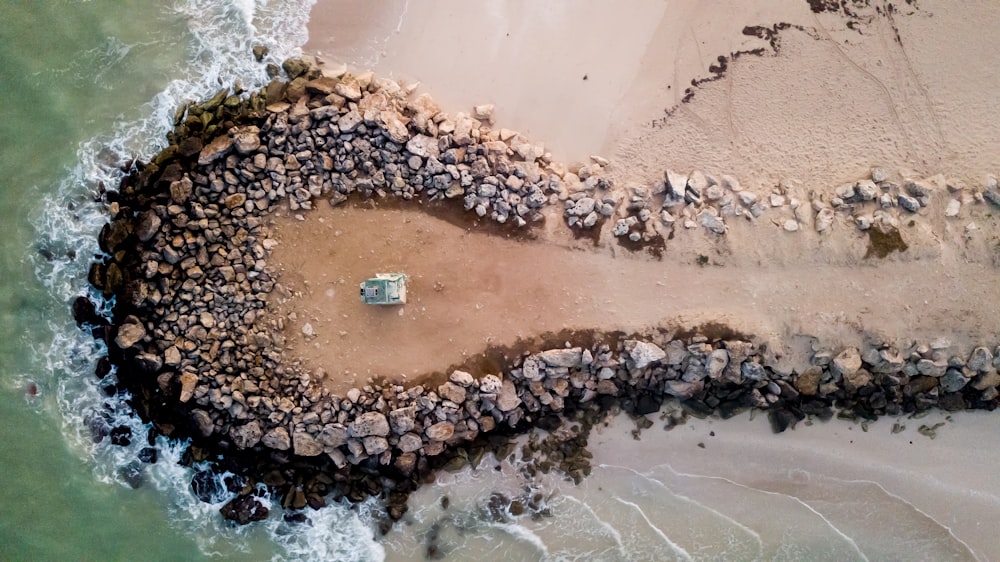 an aerial view of a beach with rocks and water