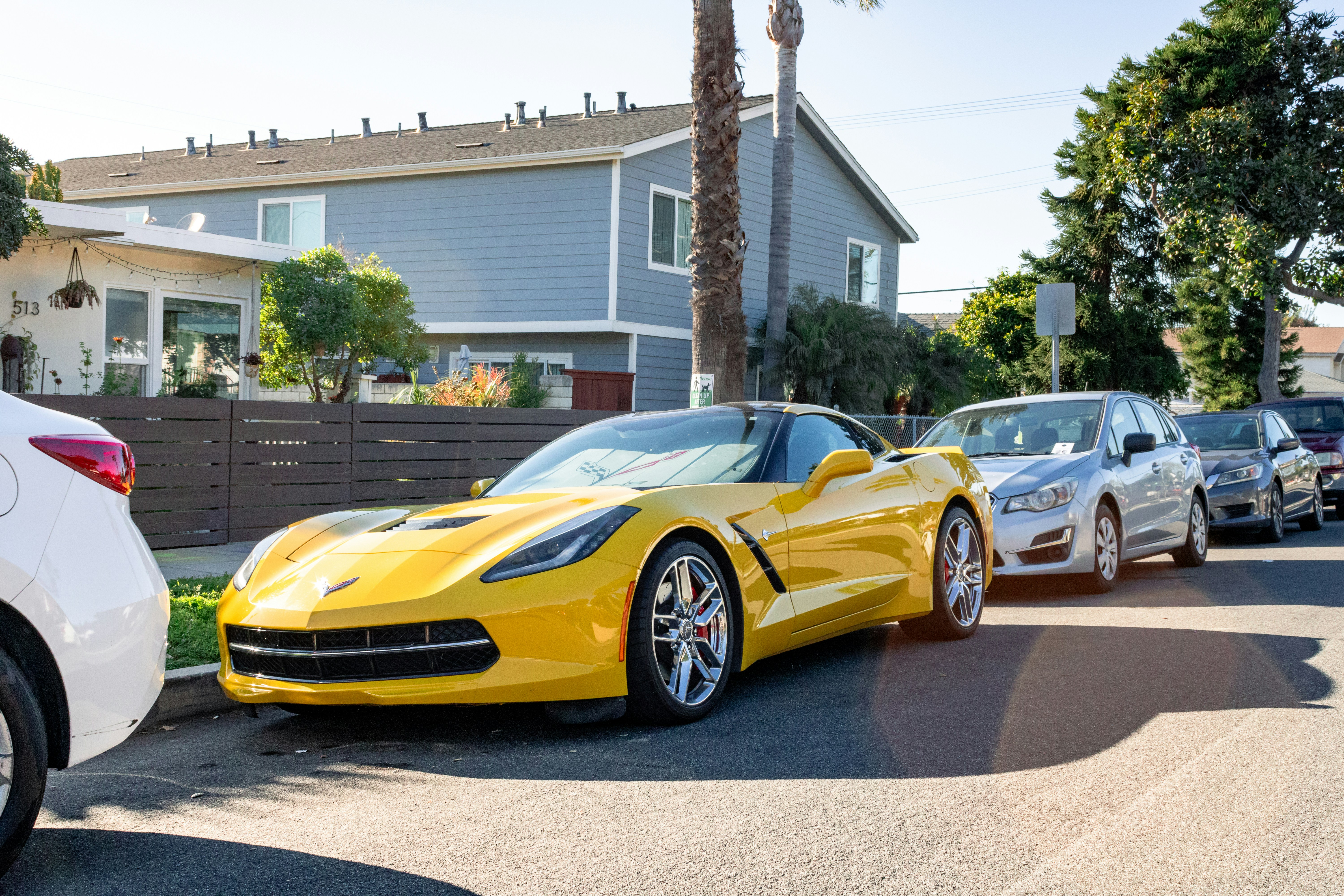 Family plugging in an electric car to a home charging station in a driveway