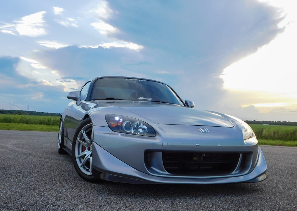 a silver sports car parked on the side of the road