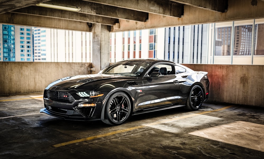 a black sports car parked in a parking garage