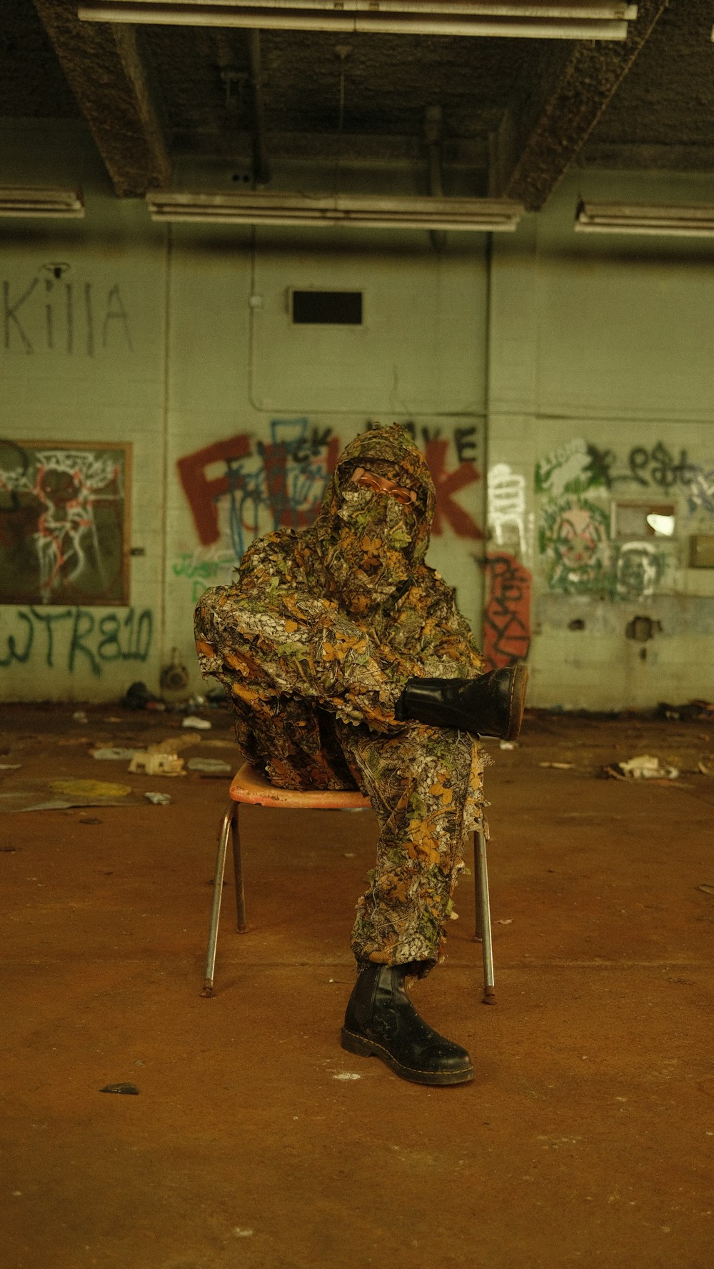 a person sitting on a chair in a room with graffiti on the walls