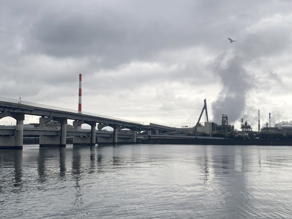 a bridge over a body of water under a cloudy sky