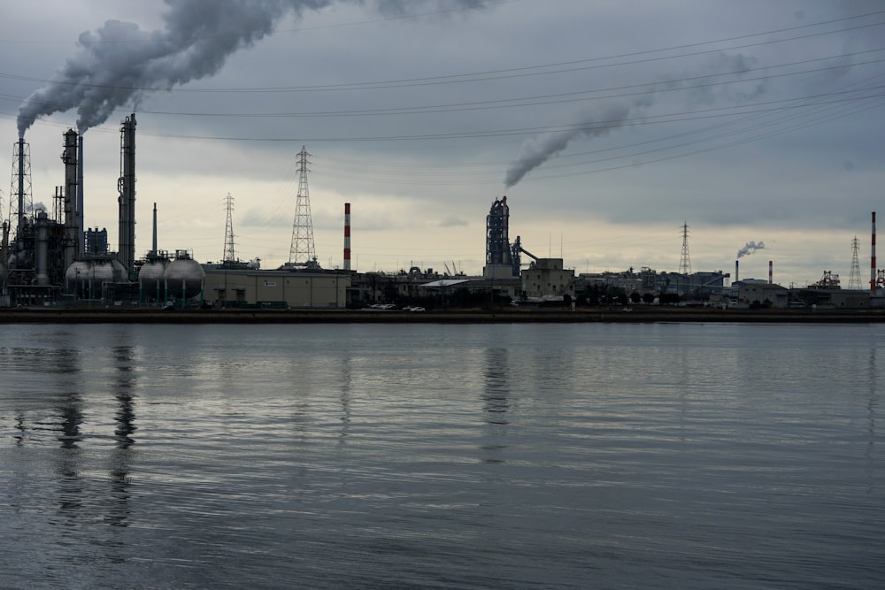 De la fumée s’échappe d’une usine près d’un plan d’eau