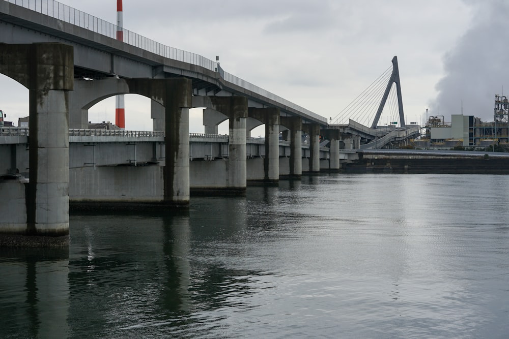 uma ponte sobre um corpo de água com uma ponte ao fundo