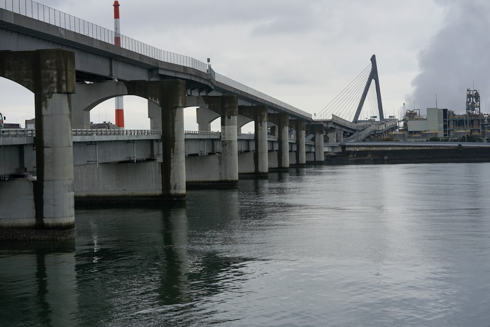 uma ponte sobre um corpo de água com uma ponte ao fundo