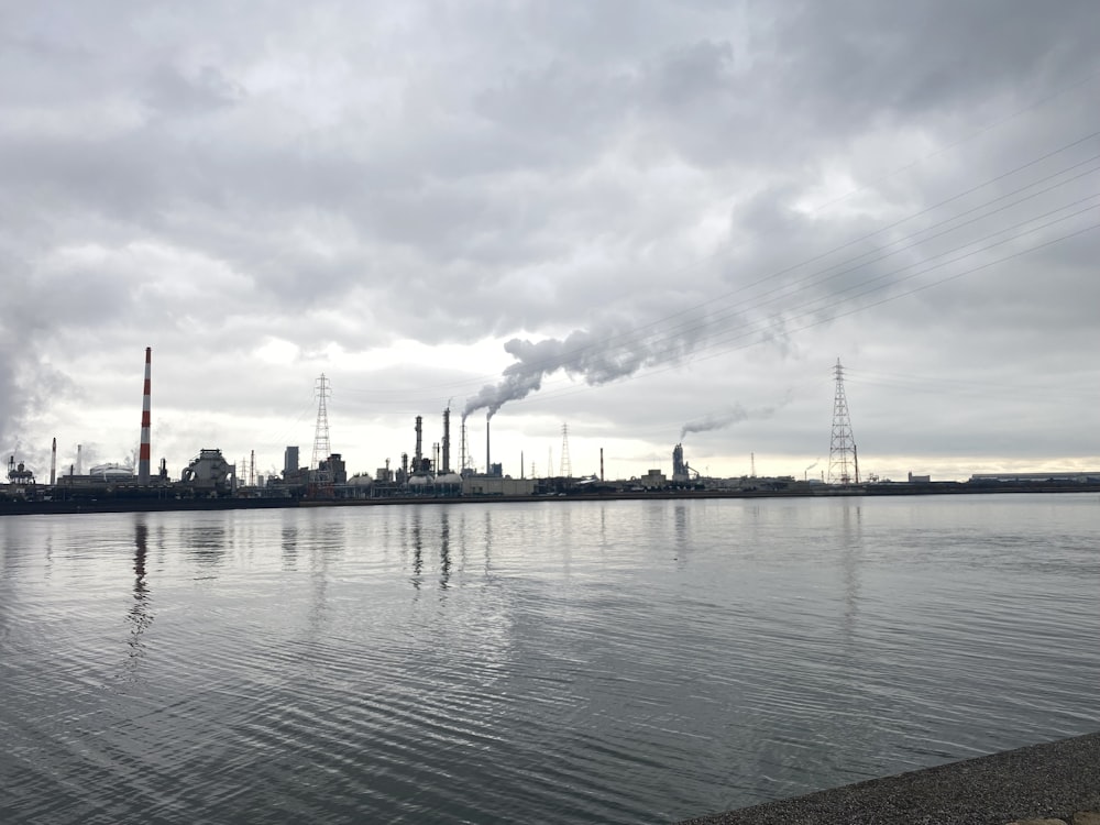 a large body of water with a factory in the background