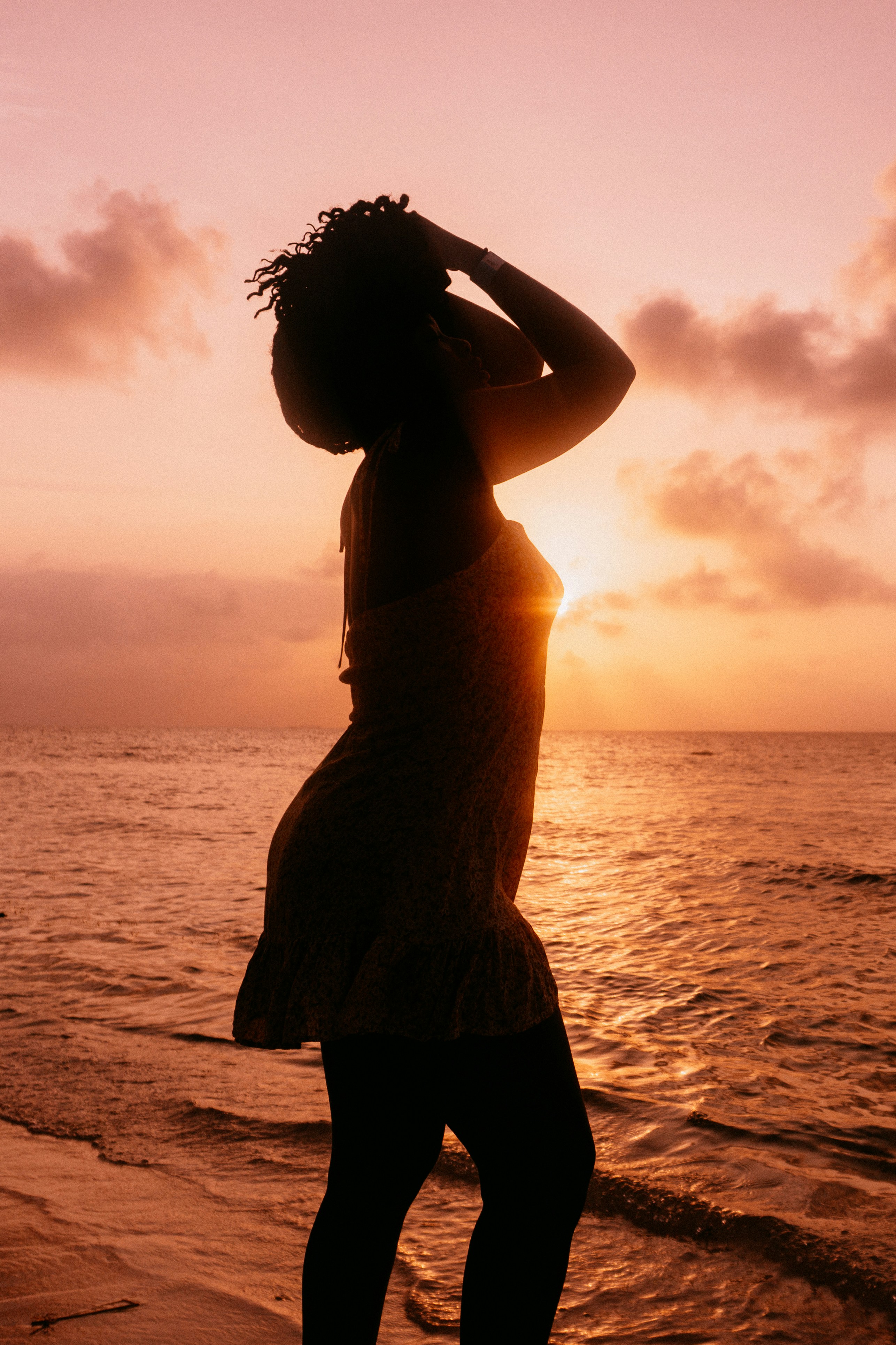 A woman standing on a beach next to the ocean photo – Free Beach Image ...